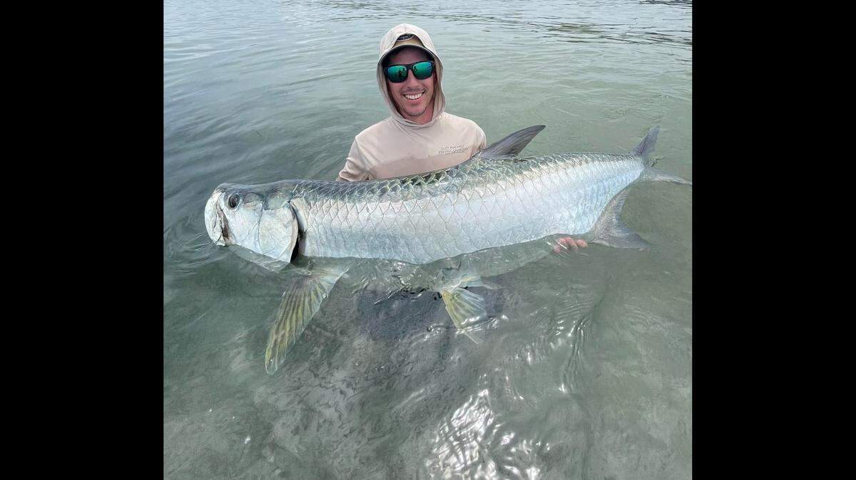 Fisherman catches large tarpon fish near Skyway in Tampa Bay